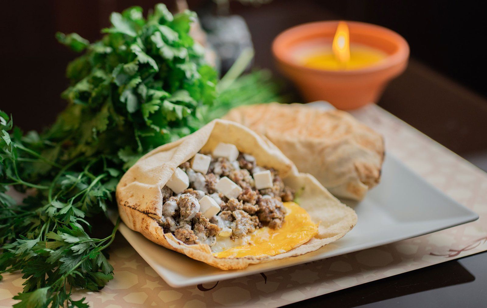 Pan de pita relleno de carne y queso sobre una bandeja