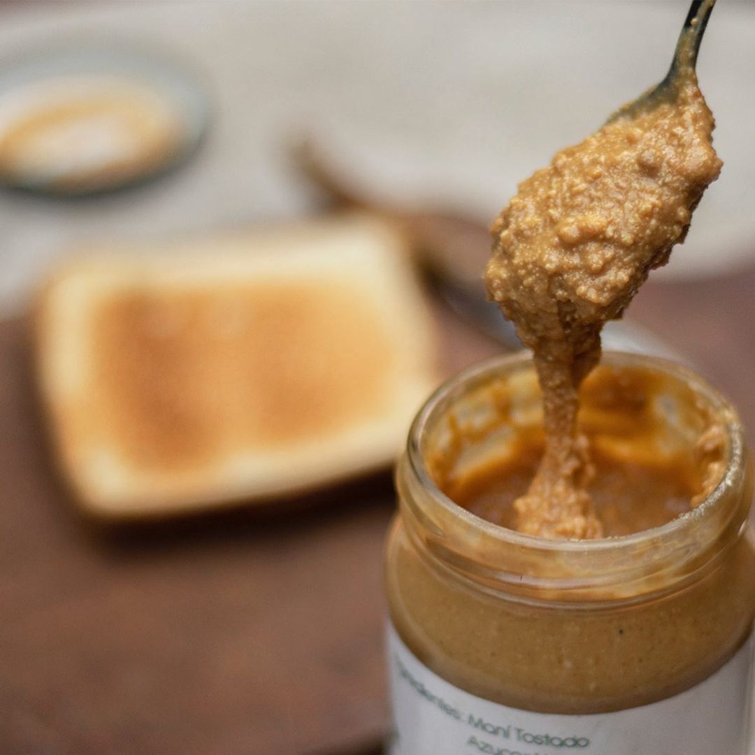 Cuchara sacando crema de cacahuete del tarro